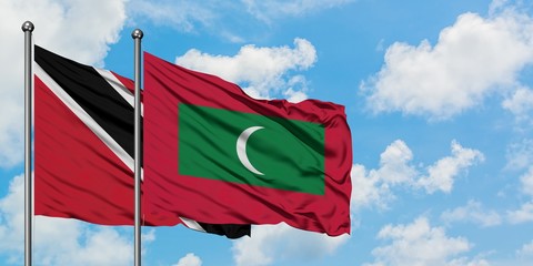 Trinidad And Tobago and Maldives flag waving in the wind against white cloudy blue sky together....
