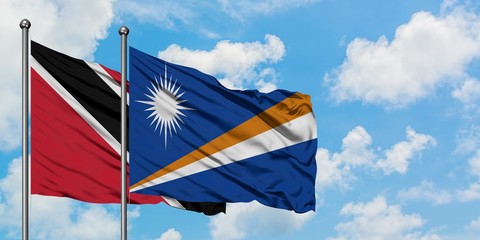 Trinidad And Tobago and Marshall Islands flag waving in the wind against white cloudy blue sky...