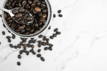 Coffee beans in a glass jar on a marble background..Top view.