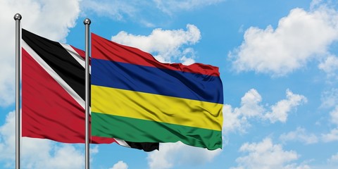Trinidad And Tobago and Mauritius flag waving in the wind against white cloudy blue sky together. Diplomacy concept, international relations.