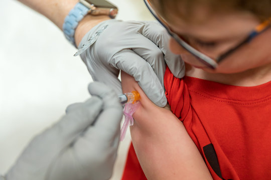 Young Boy Receiving Shot Of Vaccine In Arm, Medical Concept