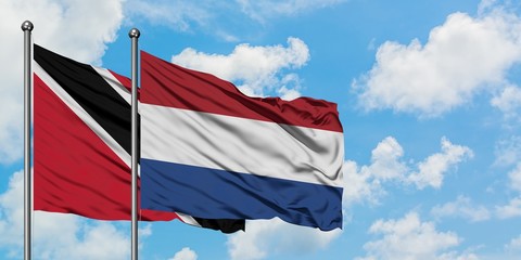 Trinidad And Tobago and Netherlands flag waving in the wind against white cloudy blue sky together. Diplomacy concept, international relations.