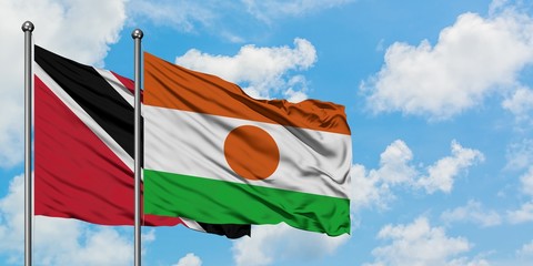 Trinidad And Tobago and Niger flag waving in the wind against white cloudy blue sky together....