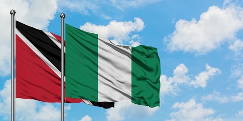 Trinidad And Tobago and Nigeria flag waving in the wind against white cloudy blue sky together. Diplomacy concept, international relations.