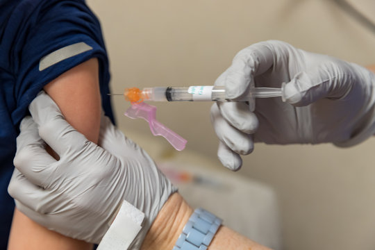 Child receiving shot of vaccine in arm, medical concept