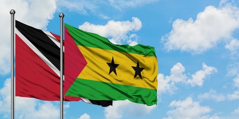 Trinidad And Tobago and Sao Tome And Principe flag waving in the wind against white cloudy blue sky together. Diplomacy concept, international relations.
