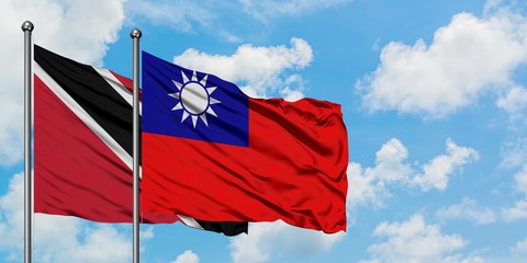 Trinidad And Tobago and Taiwan flag waving in the wind against white cloudy blue sky together. Diplomacy concept, international relations.