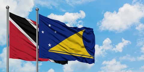 Trinidad And Tobago and Tokelau flag waving in the wind against white cloudy blue sky together....