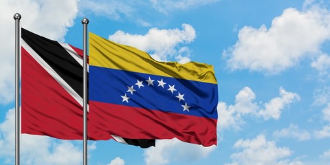 Trinidad And Tobago and Venezuela flag waving in the wind against white cloudy blue sky together. Diplomacy concept, international relations.