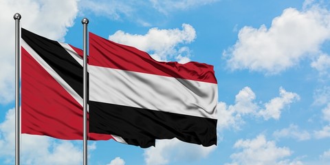 Trinidad And Tobago and Yemen flag waving in the wind against white cloudy blue sky together....