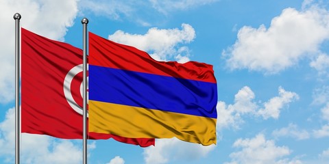 Tunisia and Armenia flag waving in the wind against white cloudy blue sky together. Diplomacy concept, international relations.