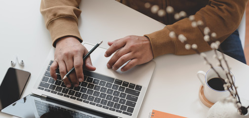 Cropped shot of man typing on laptop computer while working the project
