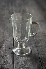 A tall glass goblet on a black wooden table.