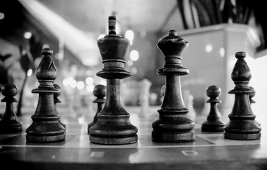 Wooden chess close up king and queen on a chess board. Black and white photo