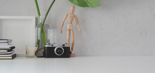 Minimal workplace with mock up frame, camera and office supplies on white table