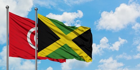 Tunisia and Jamaica flag waving in the wind against white cloudy blue sky together. Diplomacy concept, international relations.