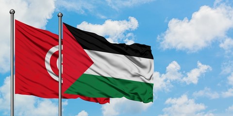 Tunisia and Palestine flag waving in the wind against white cloudy blue sky together. Diplomacy...