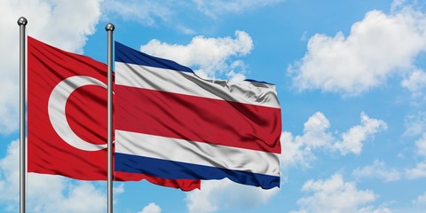 Turkey and Costa Rica flag waving in the wind against white cloudy blue sky together. Diplomacy concept, international relations.