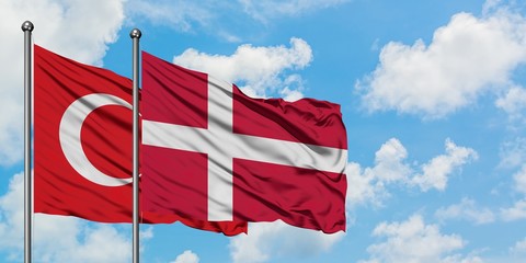 Turkey and Denmark flag waving in the wind against white cloudy blue sky together. Diplomacy concept, international relations.