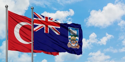 Turkey and Falkland Islands flag waving in the wind against white cloudy blue sky together. Diplomacy concept, international relations.