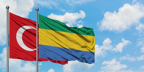 Turkey and Gabon flag waving in the wind against white cloudy blue sky together. Diplomacy concept, international relations.