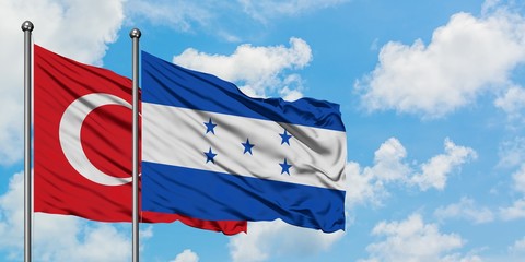 Turkey and Honduras flag waving in the wind against white cloudy blue sky together. Diplomacy...