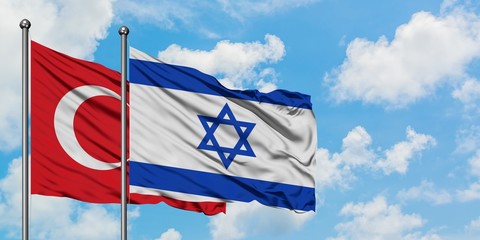 Turkey and Israel flag waving in the wind against white cloudy blue sky together. Diplomacy concept, international relations.