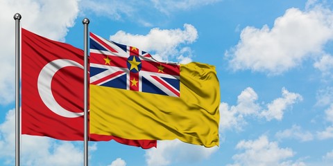 Turkey and Niue flag waving in the wind against white cloudy blue sky together. Diplomacy concept, international relations.