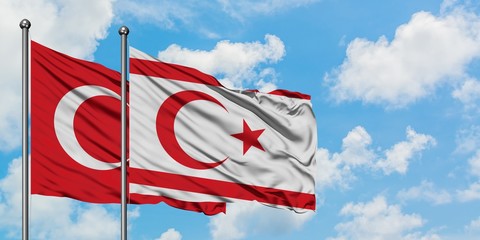 Turkey and Northern Cyprus flag waving in the wind against white cloudy blue sky together....