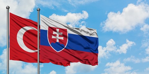 Turkey and Slovakia flag waving in the wind against white cloudy blue sky together. Diplomacy concept, international relations.