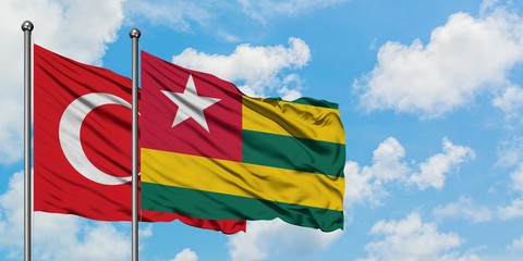 Turkey and Togo flag waving in the wind against white cloudy blue sky together. Diplomacy concept, international relations.