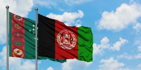 Turkmenistan and Afghanistan flag waving in the wind against white cloudy blue sky together....