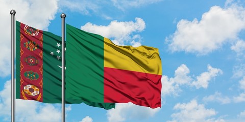 Turkmenistan and Benin flag waving in the wind against white cloudy blue sky together. Diplomacy...