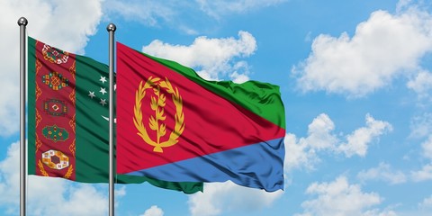 Turkmenistan and Eritrea flag waving in the wind against white cloudy blue sky together. Diplomacy concept, international relations.