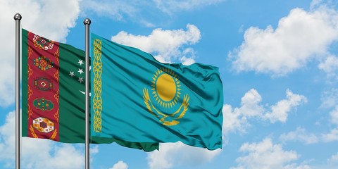 Turkmenistan and Kazakhstan flag waving in the wind against white cloudy blue sky together. Diplomacy concept, international relations.