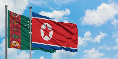Turkmenistan and North Korea flag waving in the wind against white cloudy blue sky together....