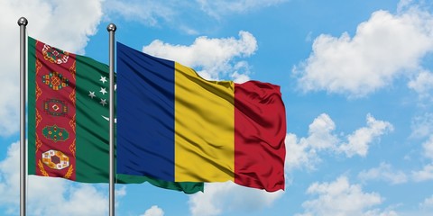 Turkmenistan and Romania flag waving in the wind against white cloudy blue sky together. Diplomacy...