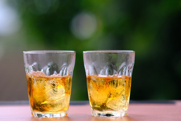 glass of whiskey and ice on wooden table