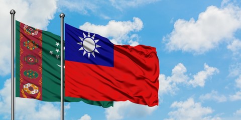 Turkmenistan and Taiwan flag waving in the wind against white cloudy blue sky together. Diplomacy...