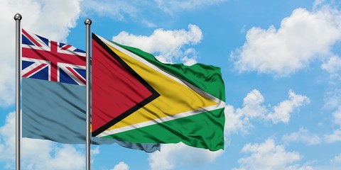 Tuvalu and Guyana flag waving in the wind against white cloudy blue sky together. Diplomacy concept, international relations.