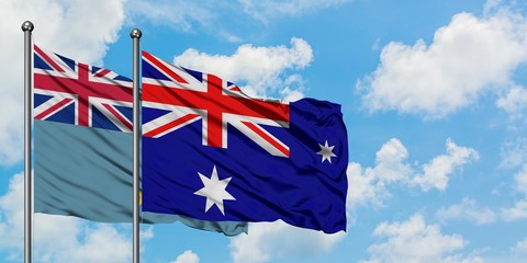 Tuvalu and Heard Island and Mcdonald Islands flag waving in the wind against white cloudy blue sky together. Diplomacy concept, international relations.