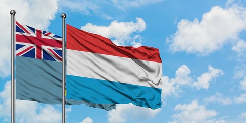 Tuvalu and Luxembourg flag waving in the wind against white cloudy blue sky together. Diplomacy concept, international relations.