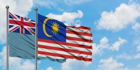 Tuvalu and Malaysia flag waving in the wind against white cloudy blue sky together. Diplomacy concept, international relations.