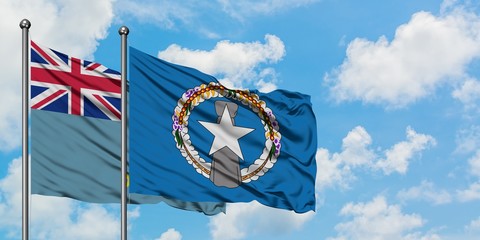 Tuvalu and Northern Mariana Islands flag waving in the wind against white cloudy blue sky together....