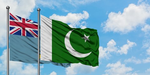 Tuvalu and Pakistan flag waving in the wind against white cloudy blue sky together. Diplomacy...