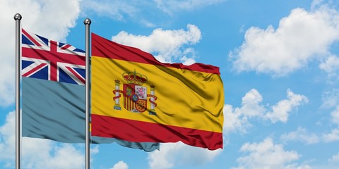 Tuvalu and Spain flag waving in the wind against white cloudy blue sky together. Diplomacy concept, international relations.