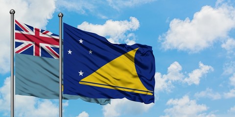 Tuvalu and Tokelau flag waving in the wind against white cloudy blue sky together. Diplomacy concept, international relations.