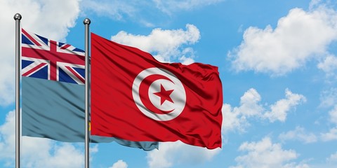 Tuvalu and Tunisia flag waving in the wind against white cloudy blue sky together. Diplomacy...