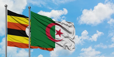 Uganda and Algeria flag waving in the wind against white cloudy blue sky together. Diplomacy...
