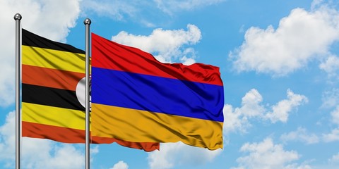 Uganda and Armenia flag waving in the wind against white cloudy blue sky together. Diplomacy concept, international relations.